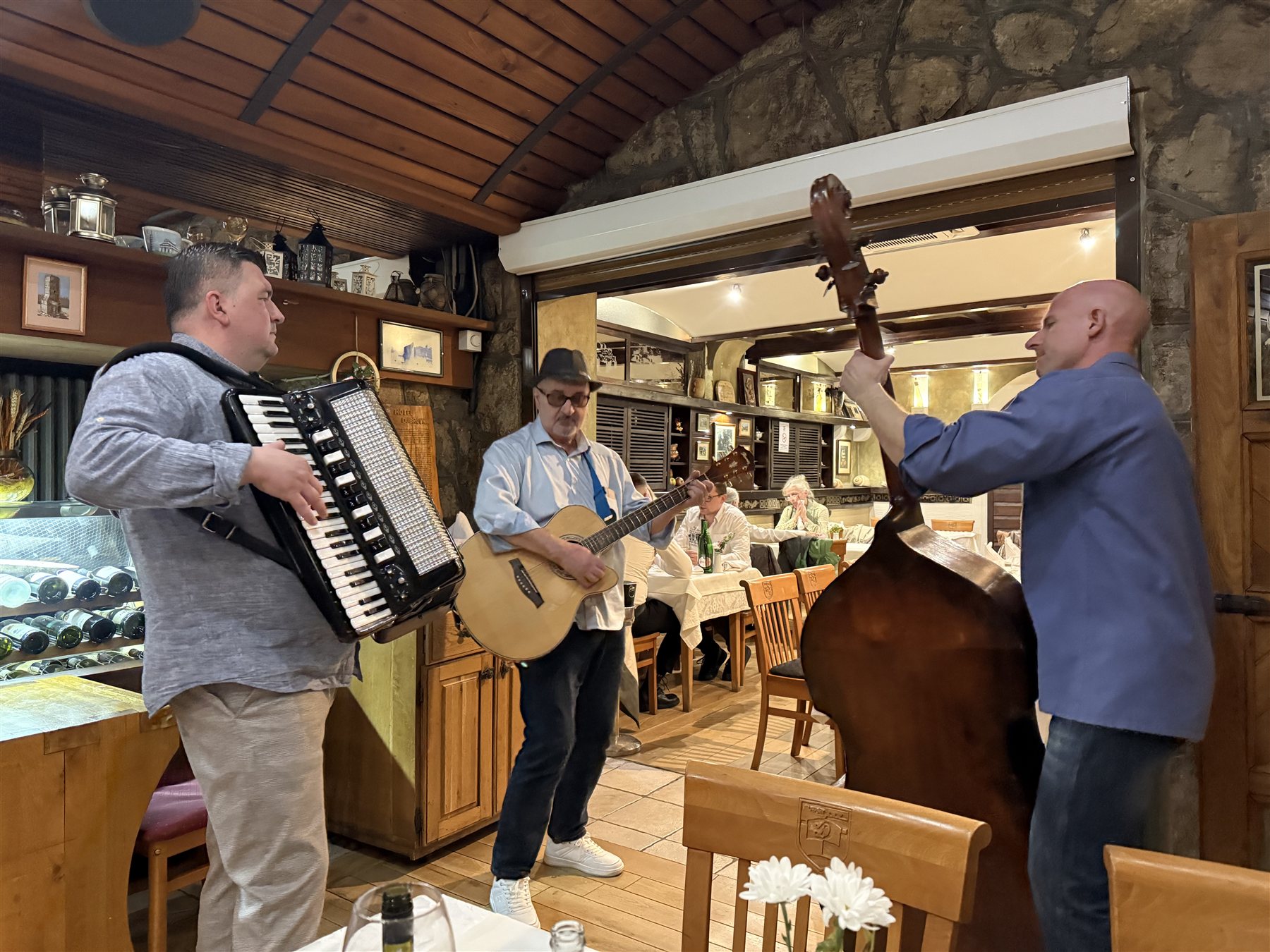 Muzičari uz harmoniku, gitaru i kontrabas u restoranu Dubrovnik